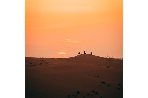 Image People at sunset in desert sitting in dunes
